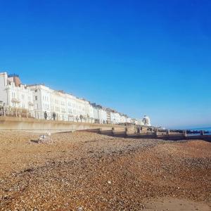 a row of buildings on a beach next to the ocean at Spacious top floor suite top of Edwardian house in Hastings