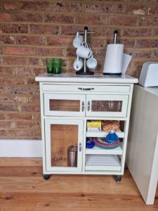 a white kitchen cart next to a refrigerator at Spacious top floor suite top of Edwardian house in Hastings