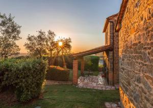 a stone house with a stone wall and a patio at Villa Giulia in Tuoro sul Trasimeno