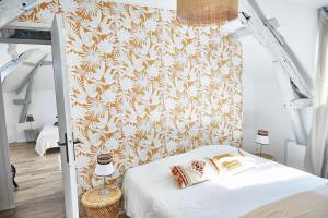 a bedroom with a white bed with a floral wallpaper at Demeure de Manneville - SPA - 1Km des plages de Cabourg in Dives-sur-Mer +37 photos