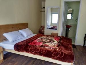 a bedroom with a large bed with a mirror at Hidden valley Lake Resort in Gircha