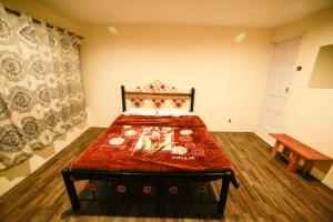 a bedroom with a bed with a red blanket at Hidden valley Lake Resort in Gircha