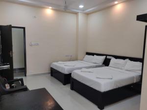 Ліжко або ліжка в номері SRI VIGNESH RESIDENCY