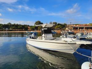 un barco blanco está atracado en el agua en Baia di Ulisse, en Porto Pozzo