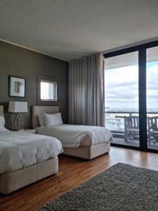 une chambre d'hôtel avec deux lits et une grande fenêtre dans l'établissement Manhattan by Smart City Stays, au Cap