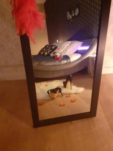einem Spiegel mit zwei Schuhen vor dem Bett in der Unterkunft escapade romantique 56 in Plouray