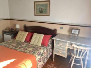 a bedroom with a bed with a desk and a desk at Fazenda Alvorada in Cunha
