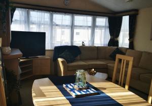 a living room with a couch and a table at Tranquil 6 Berth Luxury Holiday Home in Chichester