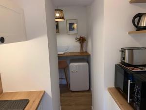 a kitchen with a white refrigerator and a counter at Le RoseGarden Studio au pied de la Gare de Rennes in Rennes +10 photos