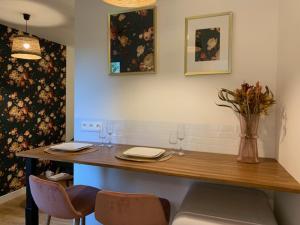a table with two chairs and a vase of flowers at Le RoseGarden Studio au pied de la Gare de Rennes in Rennes