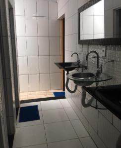 a bathroom with two sinks and a mirror at buganvile hostel in Abraão