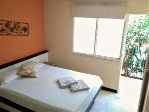 a bedroom with a bed with two folded towels on it at Casa D'mer Taganga in Taganga