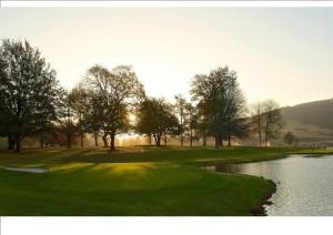 a golf course with a green and a river at Yellowwoods Farm - THE GOAT HOUSE in Curryʼs Post