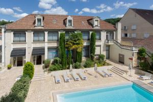 a mansion with a swimming pool in front of a building at Hotel Le Renoir in Sarlat-la-Canéda
