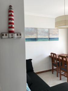 een woonkamer met een rode en witte vuurtoren aan de muur bij My Little Beach House in Praia da Barra