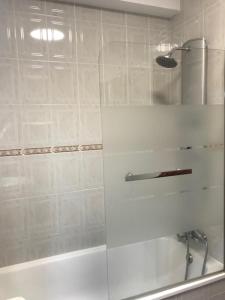 een witte badkamer met een douche en een wastafel bij My Little Beach House in Praia da Barra