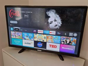 a flat screen tv sitting on top of a dresser at Waterfront Retreat - Modern Apartment in Burnham on Crouch