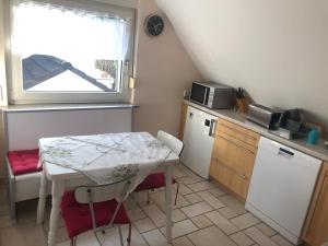 una pequeña cocina con una mesa pequeña, una mesa y una ventana en Constantin, en Bochum