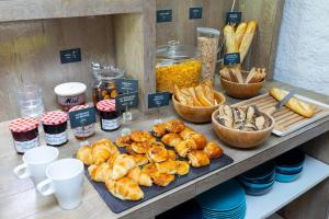 - un buffet de viennoiseries et de pains sur une table dans l'établissement Hôtel Stanley by HappyCulture, à Nancy