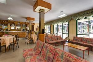 a restaurant with couches and a table and chairs at Hotel Valentino in Pinarella