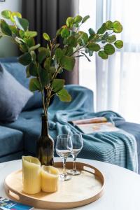 a tray with wine glasses and a vase with a plant at Sunway Pyramid View 3BR 2BR 2carpark in Petaling Jaya