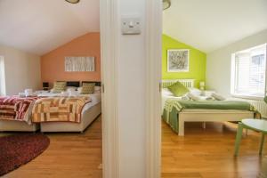 ブライトン＆ホーブにあるKemp Town House - Parking - by Brighton Holiday Letsの緑とオレンジの壁の客室で、ベッド2台が備わります。