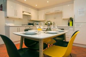 a kitchen with a table and chairs with wine glasses at Kemp Town House - Parking - by Brighton Holiday Lets in Brighton & Hove