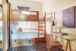 a bunk bed in a room with a desk and a bed at FOUND Hotel San Francisco in San Francisco