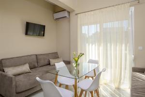 Orea Homes في أموديا: غرفة معيشة مع طاولة زجاجية وكراسي بيضاء
