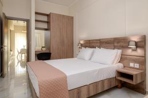 um quarto com uma cama grande e uma cabeceira em madeira em Orea Homes em Ammoudia
