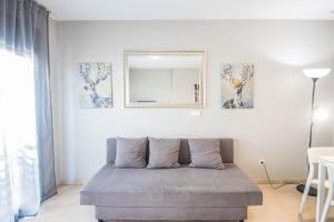 sala de estar con sofá y espejo en Recogidas Apartment by A3Rentals, en Granada
