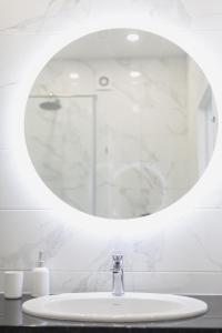 ein Badezimmer mit Waschbecken und Spiegel in der Unterkunft Arcadia romantic view in Odessa