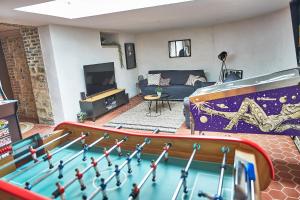 a living room with a ping pong table and a couch at Demeure de Manneville - SPA - 1Km des plages de Cabourg in Dives-sur-Mer