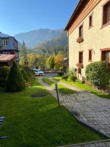 a cobblestone street next to a building with a mountain at Privát Domino in Ždiar