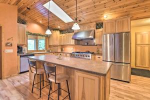 a kitchen with wooden cabinets and a large island with bar stools at Spacious Lakefront Home with Patio and Boat Dock! in Laporte