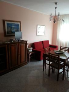 オートラントにあるAppartamento a Otranto con Vista Mareのリビングルーム(赤いソファ、テーブル付)