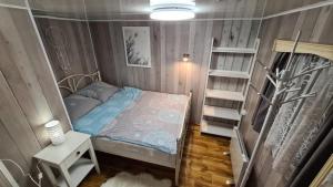 a small room with a bed and a book shelf at Siedlisko nr 3 nad jeziorem Skarlińskim, domki letniskowe, mazury, jezioro,bania in Nowe Miasto Lubawskie