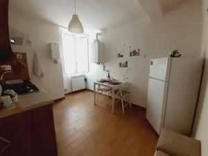 a kitchen with a refrigerator and a table and a window at Alloggio Turistico Sutri in Sutri