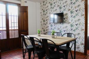 a dining room table with chairs and a television on a wall at RIBERA SUITE CÓRDOBA in Córdoba