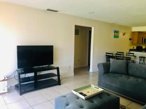 a living room with a couch and a flat screen tv at Spacious Condo close to Siesta in Sarasota