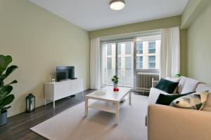 een woonkamer met een bank en een tafel bij Cosy studio in city center with sunny terrace, free NETFLIX and Wifi in Antwerpen