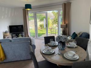a living room with a table and a couch at Stylish Boutique Bungalow in Felixstowe
