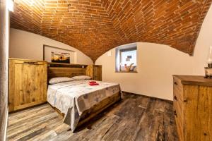 ein Schlafzimmer mit einem Bett und einer Ziegeldecke in der Unterkunft Maison Duc Apartments Alloggio ad uso turistico - VDA - JOVENÇAN - 0003 Alloggio ad uso turistico - VDA - JOVENÇAN - 0004 in Jovencan