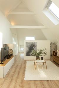 a white living room with a table and a tv at Huize Copes apartment Den Haag, 2 bed, 2 bath in The Hague