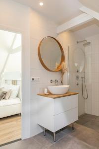 a bathroom with a white sink and a mirror at Huize Copes apartment Den Haag, 2 bed, 2 bath in The Hague