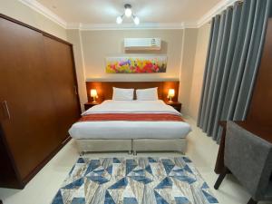 a hotel room with a bed and a rug at Royal Land Deluxe Suites رويال لاند للأجنحة الفاخرة in Duqm