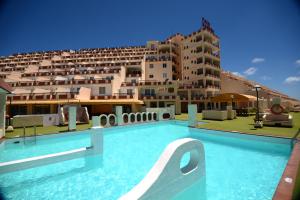 una piscina di fronte a un grande edificio di Apartamentos Palm Garden by LIVVO a Morro del Jable