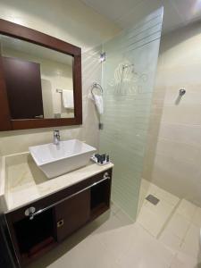 杜科姆Royal Land Deluxe Suites رويال لاند للأجنحة الفاخرة的带水槽和淋浴的浴室（带镜子）