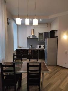 uma cozinha com uma mesa e cadeiras e um frigorífico em Apartments Nevsky 150 em São Petersburgo