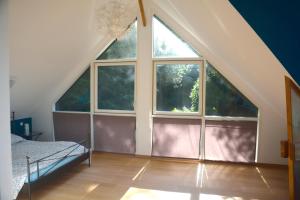 a bedroom with a large window in an attic at Villa Panorama, vue Mer et Falaises d exception in Étretat